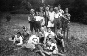 Gruppenfoto von Kindern, ca. 1935/36, Manfred Wolf war damals etwa 11 Jahre alt. Das Mädchen im weißen Kleid in der Mitte ist Clementine Scheit, eine gute Freundin. Manfred Wolf ist der in die Kamera lachende Junge direkt unter ihr.
'© Manfred Wolf