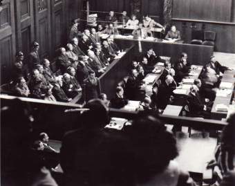 The dock (front left), prosecution counsel (front right), and interpreter’s booth (rear) in the I.G. Farben Trial in Nuremberg, as seen from the spectators’ seating area'© National Archives, Washington, DC