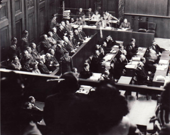 The dock (front left), prosecution counsel (front right), and interpreter’s booth (rear) in the I.G. Farben Trial in Nuremberg, as seen from the spectators’ seating area
'© National Archives, Washington, DC